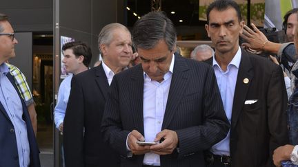 François Fillon consulte son smartphone, à Chalons-en-Champagne (Marne), le 1er septembre 2016. (MAXPPP)