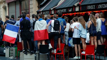 Certains spectateurs, comme ici à Paris, ont improvisé des tribunes avec des chaises pour regarder le match à la terrasse d'un bar. (CHARLES PLATIAU / REUTERS)