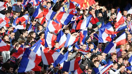 Des supporters de foot brandissant des drapeaux français à Caen (Calvados), le 22 novembre 2015. (CHARLY TRIBALLEAU / AFP)