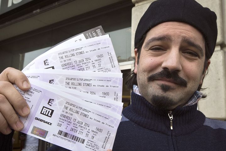 Le jours de la mise en vente des places pour le concert du 13 juin, le 28 mars 2014, un fan pose avec des billets pour les Rolling Stones, &agrave; Paris.&nbsp; (JOEL SAGET / AFP)