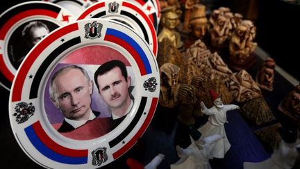 Assiettes sur lesquelles figurent les présidents syrien Bachar al-Assad et son homologue russe Vladimir Poutine (G) dans une boutique d'artisanat de la capitale syrienne, Damas, le 4 février 2016. (JOSEPH EID / AFP)