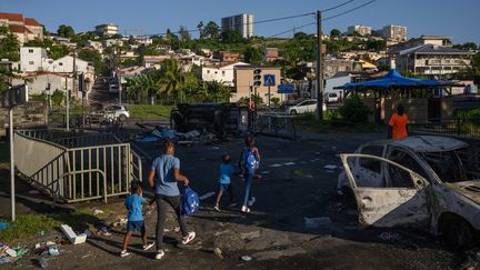 Des habitants dans une rue jonchée de débris, le 23 septembre 2024 à Fort-de-France (Martinique. (ED JONES / AFP)