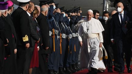 Le pape François est accueilli par le ministre des Affaires étrangères Nikos Dendias (à gauche) lors de son arrivée à l'aéroport d'Athènes (Grèce), le 4 décembre 2021. (ANDREAS SOLARO / AFP)