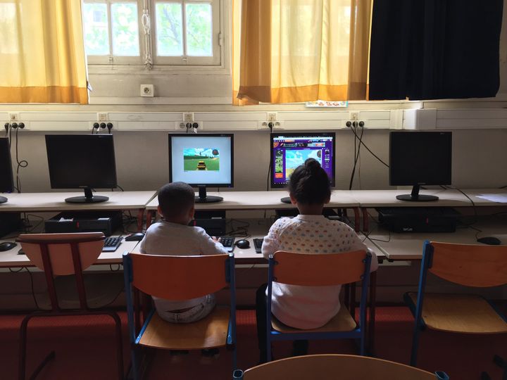 Des enfants&nbsp;dont les parents travaillent dans la lutte contre le Covid-19&nbsp;jouent&nbsp;sur un ordinateur, dans une école à Paris, le 11 mai 2020. (ELISE LAMBERT / FRANCEINFO)