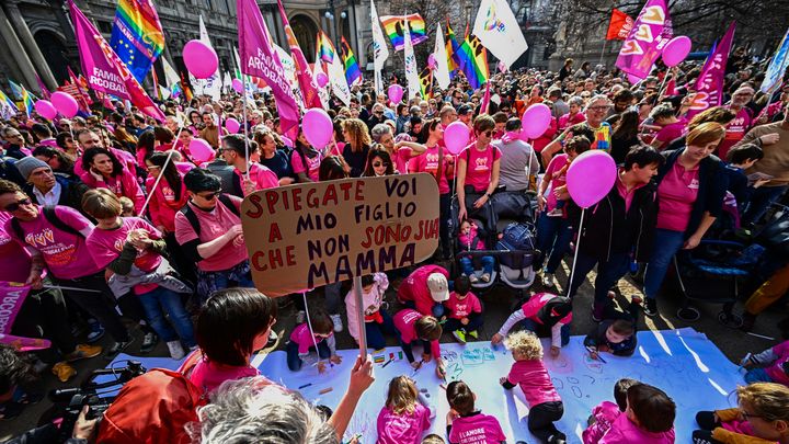 Une femme brandit une pancarte "Expliquez à mon fils que je ne suis pas sa mère", le 18 mars 2023, lors d'une manifestation pour les droits des personnes LGBT+ à Milan (Italie). (GABRIEL BOUYS / AFP)