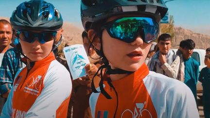 Reihane (à droite), jeune athlète de 18 ans lors d'une course aux côtés de l'équipe afghane de cyclisme féminin.&nbsp; (Capture d'écran chaîne Youtube de Neman Noori)