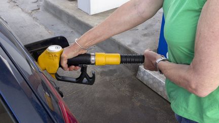 Une automobiliste dans une station-service, le 15 mai 2022. Photo d'illustration. (JEAN-MARC LALLEMAND / MAXPPP)