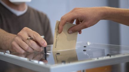 Une personne vote pour les élections régionales et départementales, le 27 juin 2021 à Dijon (Côte-d'Or). (EMMA BUONCRISTIANI / MAXPPP)