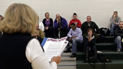 Un partisan du républicain Rick Santorum lit une déclaration de son candidat au cours d'une réunion d'électeurs dans une école de Des Moines pendant le caucus de l'Iowa, le 3 janvier 2012. (Reuters - Brian Frank)