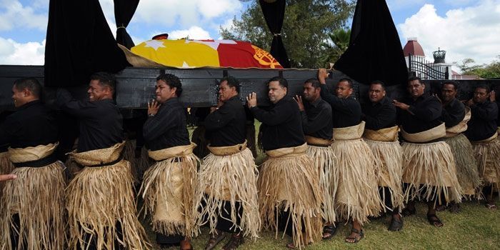 Vêtus de noir et du traditionnel ta'ovala, cent cinquante hommes portent le catafalque du roi du Tonga George Tupou V jusqu'à la tombe du souverain. (AFP PHOTO / Torsten BLACKWOOD)