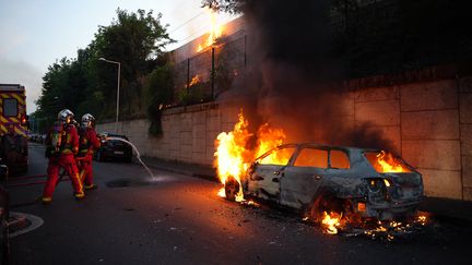 Des pompiers interviennent après l'incendie d'un véhicule lors de heurts à Nanterre, dans les Hauts-de-Seine, le 27 juin 2023. (ZAKARIA ABDELKAFI / AFP)