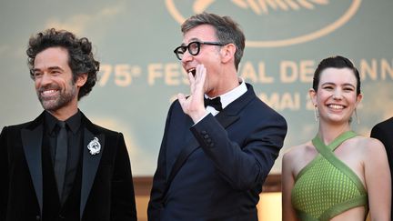 Excités à l'idée de dévoiler&nbsp;"Coupez !", Romain Duris, Michel Hazanavicius et sa fille Simone, qui fait ses premiers pas en tant qu'actrice dans ce film, affichent un&nbsp;sourire jusqu'aux oreilles. (LOIC VENANCE / AFP)