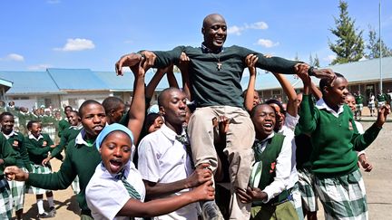 Le frère franciscain Peter Tabichi, 36 ans, sacré Meilleur enseignant du monde, est accueilli par ses élèves au Kenya en avril 2019, quelques jours après l'obtention de son prix à Dubaï. (TONY KARUMBA / AFP)