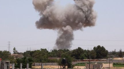 De la fumée s'élève dans le ciel de Tajura, dans la banlieue de Tripoli, après un raid de l'OTAN le 1er juillet 2011 (AFP - MAHMUD TURKIA)