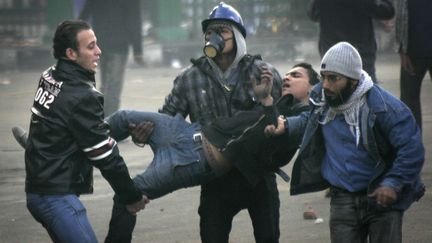 Des manifestants &eacute;vacuent l'un des leurs, bless&eacute; dans les affrontements avec l'arm&eacute;e &eacute;gyptienne, le 17 d&eacute;cembre 2011 au Caire. (MOHAMMED ABU ZAID / AP / SIPA)