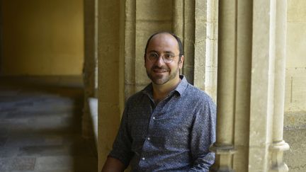 Le claveciniste et chef d'orchestre Louis-Noël Bestion de Camboulas dans le cloître de l'abbaye d'Ambronay lors du 44e Festival de musique baroque et ancienne d'Ambronay, le 16 septembre 2023. (BERTRAND PICHENE / FESTIVAL D'AMBRONAY)