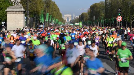 Des coureurs descendent les Champs-Elysées, le 9 avril 2017, lors du 41e marathonde Paris. (ERIC FEFERBERG / AFP)