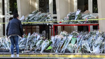 Les fleurs en hommage à Dominique Bernard déposées devant la cité scolaire Gambetta à Arras, le 14 octobre 2023. (DENIS CHARLET / AFP)