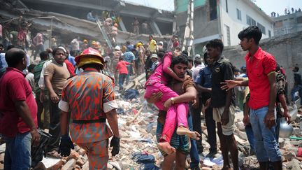 Les secours&nbsp;luttent, le 24 avril 2013 dans la banlieue de Dacca (Bangladesh), pour extraire des survivants pi&eacute;g&eacute;s sous les d&eacute;combres d'un immeuble effondr&eacute;. (MUNIR UZ ZAMAN / AFP)