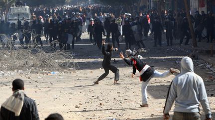 Des manifestants jettent des pierres sur la police anti-&eacute;meute le 5 f&eacute;vrier 2012 au Caire (Egypte). (MAHMUD HAMS / AFP)