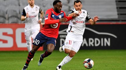 Le Lillois Jonathan Ikone au duel avec le Montpellierain Teji Savanier, le 16 avril 2021 au stade Pierre-Mauroy. (DENIS CHARLET / AFP)