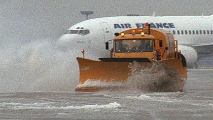 Un chasse-neige circule sur une piste d'atterrissage de l'aéroport de Roissy. (AFP - Jack Guez)