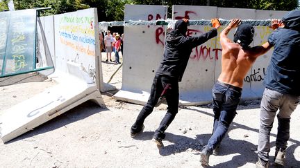 Des opposants au projet de stockage des déchets radioactifs de Bure (Meuse) détruisent un mur de protection du chantier, le 14 août 2016. (FRANCOIS NASCIMBENI / AFP)