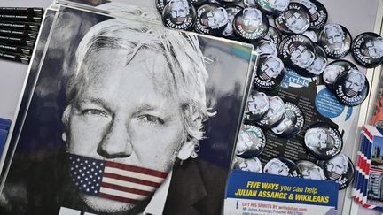 Une affiche montrant la bouche de Julian Assange couverte d'un drapeau américain est disposée sur une table lors d'une manifestation en soutien au fondateur de WikiLeaks, le 17 mai 2022, à Londres. (JUSTIN TALLIS / AFP)