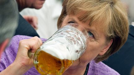 La chanceli&egrave;re allemande, Angela Merkel, se pr&ecirc;te &agrave; la traditionnelle "bi&egrave;re du matin" lors de la Gillamoos, une c&eacute;l&egrave;bre&nbsp;foire en Bavi&egrave;re (Allemagne), le 3 septembre 2012.&nbsp; (PETER KNEFFEL / DPA / MAXPPP)