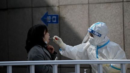 Une femme testée au Covid-19 à Pékin le 15 mars 2022. (NOEL CELIS / AFP)