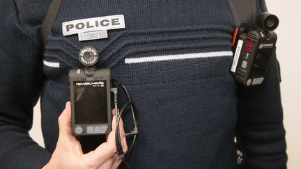 Un policier arbore deux caméras-piétons lors de l'inauguration du commissariat des Mureaux (Yvelines), le 8 avril 2016. (JACQUES DEMARTHON / AFP)