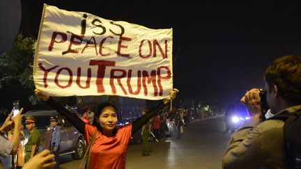 La musicienne Mai Khoi a brandi une pancarte&nbsp;devant Donald Trump, à Hanoï (Vietnam), le 11 novembre 2017. (STRINGER / AFP)