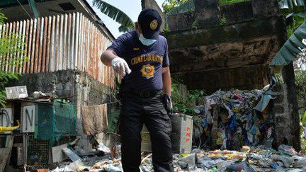 Un policier à la recherche de preuves après que des supposés trafiquants de drogue ont été tués par les forces de l'ordre dans un quartier musulman de Manille, le 3 juillet 2016.  (TED ALJIBE / AFP)