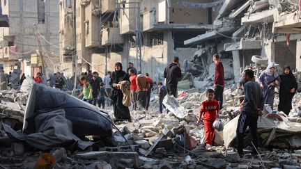 Des Palestiniens marchent au milieu des décombres dus à des frappes à Jabalia, dans le Nord de Gaza, le 10 novembre 2024. (OMAR AL-QATTAA / AFP)