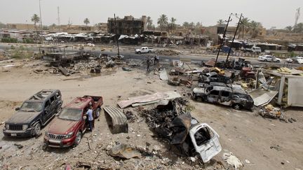 Des habitants regardent les d&eacute;g&acirc;ts provoqu&eacute;s par un attentat-suicide sur un march&eacute; de Khan Bani Saad, le 18 juillet 2015, au nord de Bagdad (Irak). (AHMED SAAD / REUTERS )