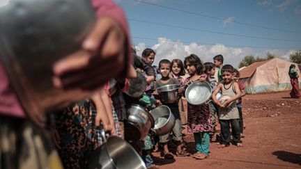 Des enfants font la queue pour recevoir de la nourriture à Idleb, en Syrie, le 7 octobre 2019.&nbsp; (MUHAMMED SAID / ANADOLU AGENCY / AFP)