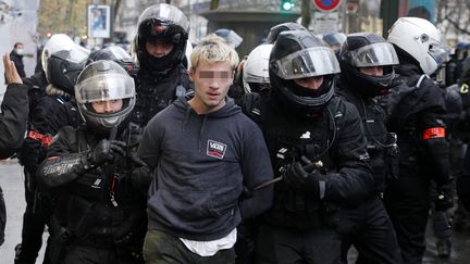 Des policiers arrêtent un jeune homme le 12 décembre 2020 à Paris durant la manifestation contre la proposition de loi sur la "sécurité globale". (GEOFFROY VAN DER HASSELT / AFP)