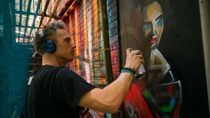 Le street artist Dan Kitchener peint à la bombe devant un bar de Hong Kong.
 (Anthony Wallace / AFP)