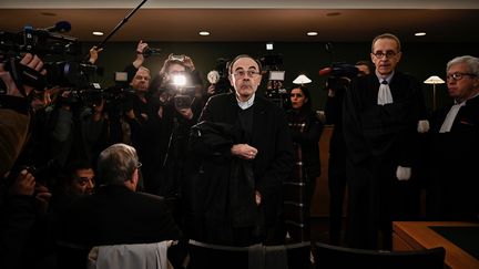 L'achevêque de Lyon, Philippe Barbarin, entouré de ses avocats et de journalistes, au premier jour de son procès, le 7 janvier 2019. (JEFF PACHOUD / AFP)