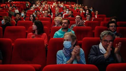 Les spectateurs applaudissant avant la projection du film "Les Parfums", lors de la réouverture des salles de cinéma, le 21 juin 2020 à Paris. (ABDULMONAM EASSA / AFP)