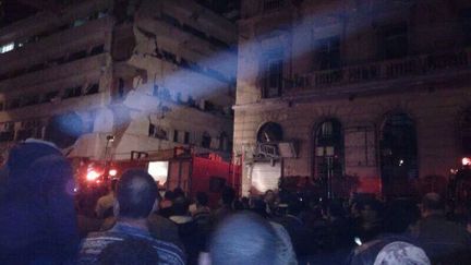 La foule devant le b&acirc;timent de la police de Mansoura (Egypte), vis&eacute; par un attentat &agrave; la voiture pi&eacute;g&eacute;e, le 24 d&eacute;cembre 2013. ( REUTERS)