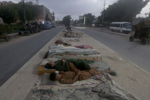 Des ouvriers dorment sur la médiane d'une route au cours d'une chaude matinée d'été à Karachi, au Pakistan, le mercredi 11 mai 2022.&nbsp; (FAREED KHAN/AP/SIPA / SIPA)