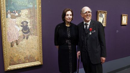 Le couple Hays posent à côté de l'oeuvre d'Edouard Vuillard, "Les Premiers Pas" (1894) à l'occasion de l'exposition de leur collection en 2013 au Musée d'Orsay. 
 (FRANCOIS GUILLOT / AFP)