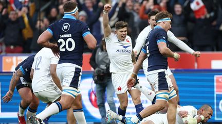 Matthieu Jalibert célèbre l'essai de Gaël Fickou à la fin du match contre l'Ecosse, dans le Tournoi des six nations, le 26 février 2023. (ANNE-CHRISTINE POUJOULAT / AFP)