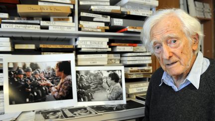 Le photographe Marc Riboud pose avec deux de ses clichés les plus célèbres, dans sa maison de Nancy (Meurthe-et-Moselle), le 9 décembre 2011. (MAXPPP)