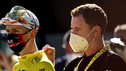 Tadej Pogacar et un membre du staff UAE Team Emirates, le 9 juillet 2022, à la fin de la huitième étape du Tour de France à Lausanne (Suisse). (MARCO BERTORELLO / AFP)