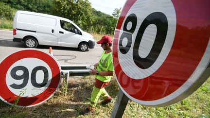 Des employés de la&nbsp;Direction interdépartementale des routes de l'Est remplacent des panneaux de limitation de vitesse.Modifier le media (2856183)  (SEBASTIEN BOZON / AFP)