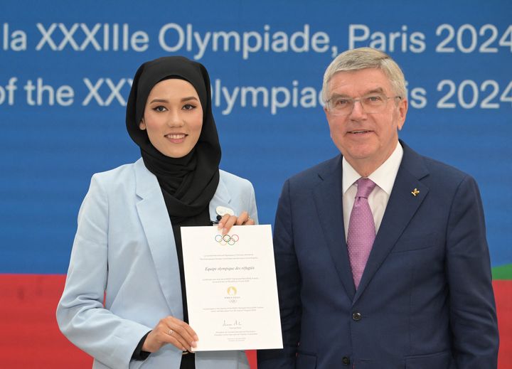 Masomah Ali Zada, choisie par le CIO pour être la cheffe de mission de l'équipe des réfugiés aux Jeux de Paris, pose avec Thomas Bach, président du Comité international olympique. (ALAIN JOCARD / AFP)