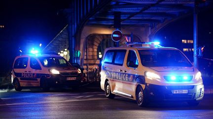 Des véhicules de police devant le Pont de Bir Hakeim à Paris, après l'attaque au couteau qui a fait un mort et deux blessés, le 2 décembre 2023. (DIMITAR DILKOFF / AFP)