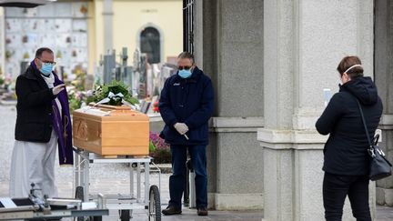 Une proche filme le service funéraire d'un défunt du covid-19 pour sa famille vivant en Israël, à Bolgare, en Lombardie (Italie), le 23 mars 2020.&nbsp; (PIERO CRUCIATTI / AFP)